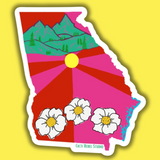 Colorful sticker of a stylized map of Georgia with mountains, sun, and flowers on a yellow background.