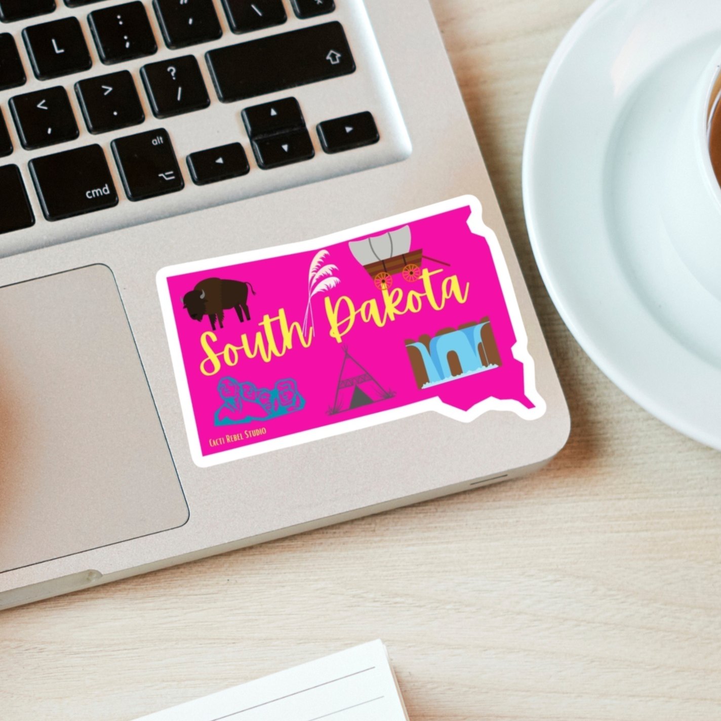 Laptop with a sticker for the state of South Dakota, with Mount Rushmore on it. 